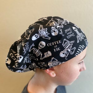 May include: Black and white skull and skeleton print scrub hat with the text "Coffee or Die" and "Death before Decaf".