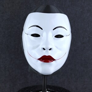 May include: A white mask with a black outline and red lips. The mask has a traditional Japanese design.