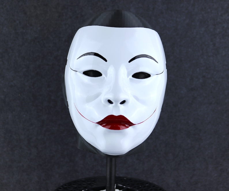 May include: A white mask with a black outline and red lips. The mask has a traditional Japanese design.
