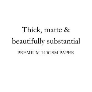 May include: A white graphic featuring black text that reads: Thick, matte & beautifully substantial. Below this, the text reads: PREMIUM 140GSM PAPER. This text describes the physical characteristics of a sheet of premium paper stock.
