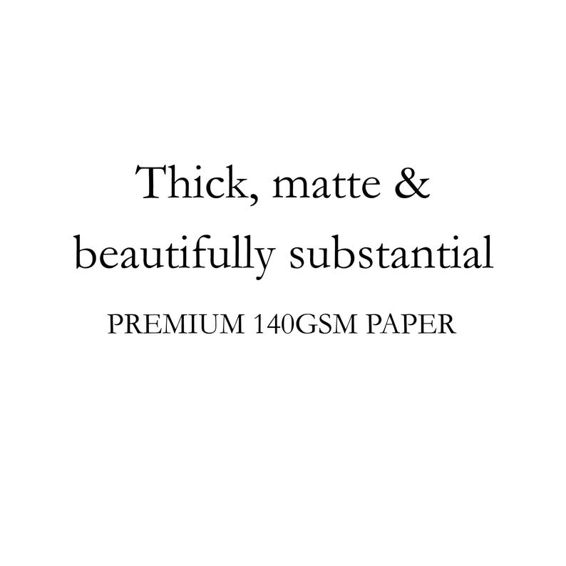 May include: A white graphic featuring black text that reads: Thick, matte & beautifully substantial. Below this, the text reads: PREMIUM 140GSM PAPER. This text describes the physical characteristics of a sheet of premium paper stock.