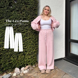 May include: A woman wearing a light pink sweat suit, consisting of a jacket and wide-leg pants. The pants have a drawstring waist. The image also shows a sewing pattern for "The Leo Pants". The woman is wearing a white tank top and tan shoes.