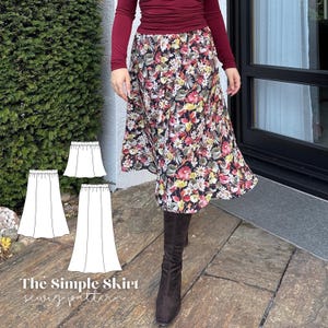 May include: A floral print skirt with a black background, featuring a variety of colorful flowers. The skirt is paired with a burgundy long-sleeve top and brown boots. The image also includes a sewing pattern with the text "The Simple Skirt sewing pattern."