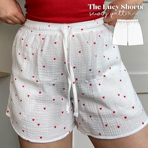 May include: White shorts with a red heart print and a drawstring waist. The shorts are made of a soft, lightweight fabric. The Lucy Shorts sewing pattern.