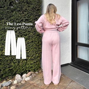 May include: A light pink sweat suit, consisting of a cropped sweatshirt and wide-leg pants. The pants have a high waist and a seam down the front. The image also shows a sewing pattern for "The Leo Pants".