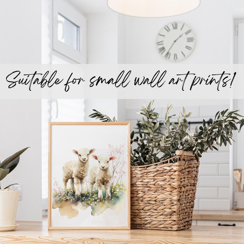 May include: A watercolor painting of two white lambs standing in a field of flowers. The painting is framed in a simple wooden frame and is suitable for small wall art prints.
