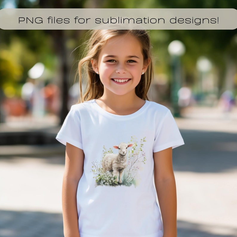May include: A white t-shirt with a watercolor illustration of a white lamb standing in a field of green grass and pink flowers.