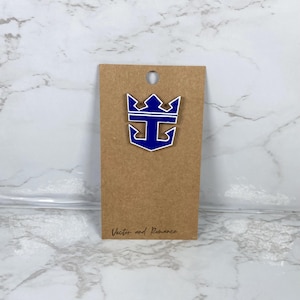 May include: A blue and white anchor and crown design pin on a brown card. The pin is in the shape of an anchor with a crown on top. The card has a small hole at the top and the words "Vector and Romance" printed at the bottom.