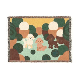 Peut inclure: Un plaid tissé rectangulaire présentant une illustration graphique de trois caniches aux couleurs crème, rose et marron. La scène comprend des arbres et des buissons circulaires stylisés verts et marron sur un ciel jaune, avec des bords à franges.
