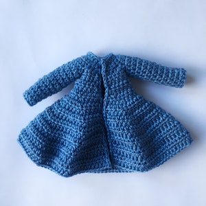 K&ouml;nnte beinhalten: Ein blauer H&auml;kelcardigan mit langen &Auml;rmeln und einem ausgestellten Saum.