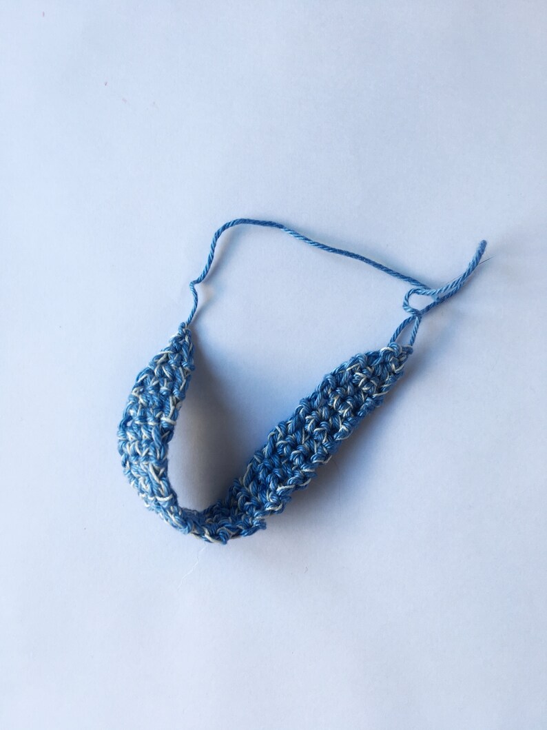 K&ouml;nnte beinhalten: Ein blaues und wei&szlig;es geh&auml;keltes Stirnband mit einem einfachen Design.
