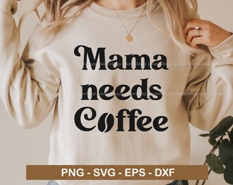 Pode incluir: Uma camisa de moletom branca com o texto "Mama needs Coffee" em letras pretas com um gráfico de grão de café. O texto está em um estilo de fonte retrô. A camisa de moletom está sendo usada por uma pessoa.
