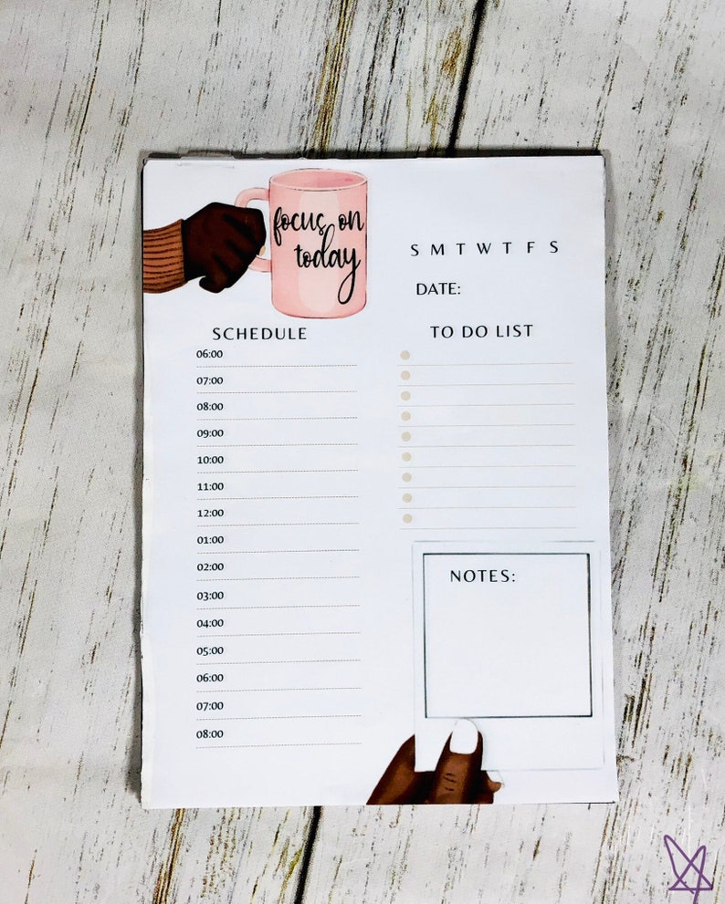 May include: A white dry erase board with a pink mug illustration and the text "focus on today". The board has a daily schedule, a to-do list, and a notes section.
