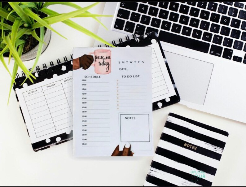 May include: A black and white polka dot planner with a daily schedule and to-do list. The planner has a pink mug with the text "focus on today" on it.