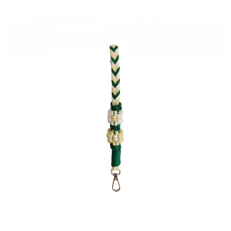 May include: A macrame wrist strap in green, white, and cream colors. The strap features a braided top section, two decorative floral knots, and a silver-colored clasp. The strap is designed to be attached to a keychain or other small items.