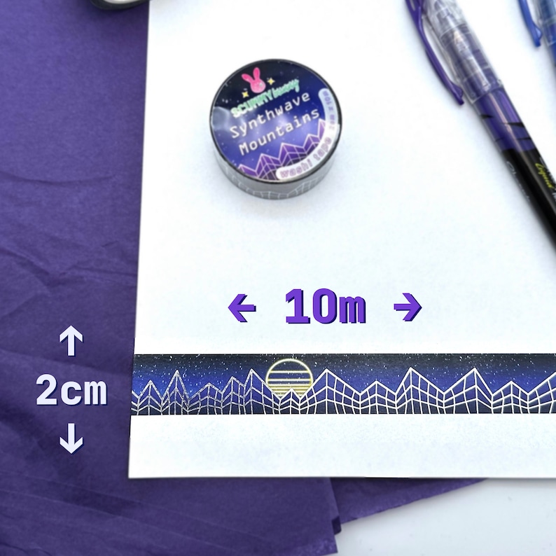 Op de afbeelding: Een rol zwarte en witte washi tape met een ontwerp van een sterrenhemel, bergen en een zonsondergang. De tape is 10 meter lang en 2 centimeter breed. De tape is gelabeld "Scunny Honey Synthwave Mountains".