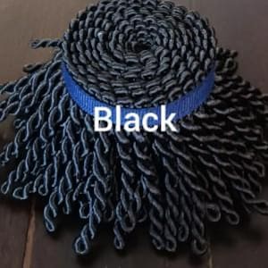 May include: A coil of black twisted rope with a blue band around the center. The word "Black" is printed in white on the blue band. The rope is tightly wound in a spiral.