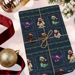 May include: A wrapped gift with dark blue wrapping paper featuring cartoon creatures in Santa hats and scarves. The gift is tied with twine and surrounded by Christmas ornaments and ribbon.