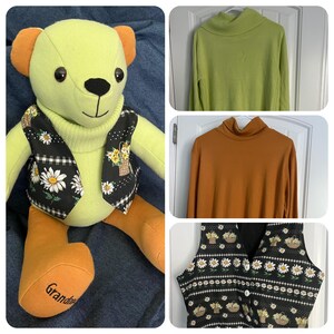 Op de afbeelding: Een handgemaakte teddybeer gemaakt van een lichtgroene coltrui en oranje stof, met een zwart vestje met een print van witte madeliefjes en mandjes. Op de voet van de beer staat het woord Grandma geborduurd. Inclusief een groene en een oranje trui.
