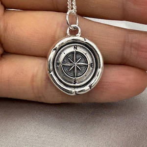 May include: Silver compass pendant necklace with a detailed compass design and a silver chain.