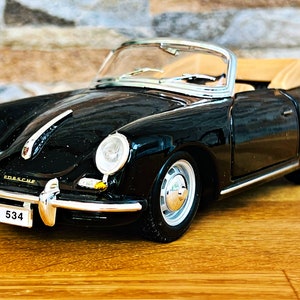 May include: Black convertible model car with a tan interior and a number plate that reads "S-DA 534".