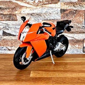 May include: Orange and black motorcycle model with the text "RC8" on the side.