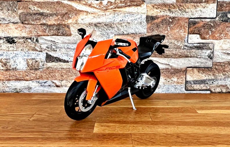 May include: Orange and black motorcycle model with the text "RC8" on the side.