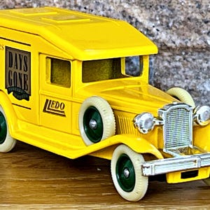 May include: Yellow toy delivery van with "Days Gone" logo and "Collectors Club Autumn 1990" text on the side. The van has a white roof and white tyres with green rims.