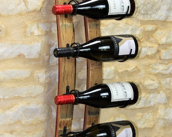 Può includere: Un porta bottiglie di vino in legno con cinque bottiglie di vino. Il porta bottiglie è realizzato in legno riciclato e ha un aspetto rustico. Le bottiglie sono di diversi colori e hanno etichette.
