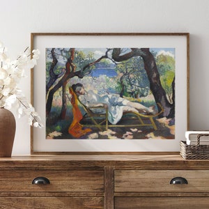 May include: A framed painting of a woman reclining on a chaise lounge in a garden setting. The woman is wearing a white dress and a red scarf. The garden is filled with trees and flowers. The painting is done in a style reminiscent of Impressionism.