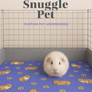 May include: A white guinea pig sits on a blue fleece pet bed with a pattern of brown hamsters and white daisies. The bed is inside a wire cage. The text "Snuggle Pet CUSTOM-PET ACCESSORIES" is above the cage.
