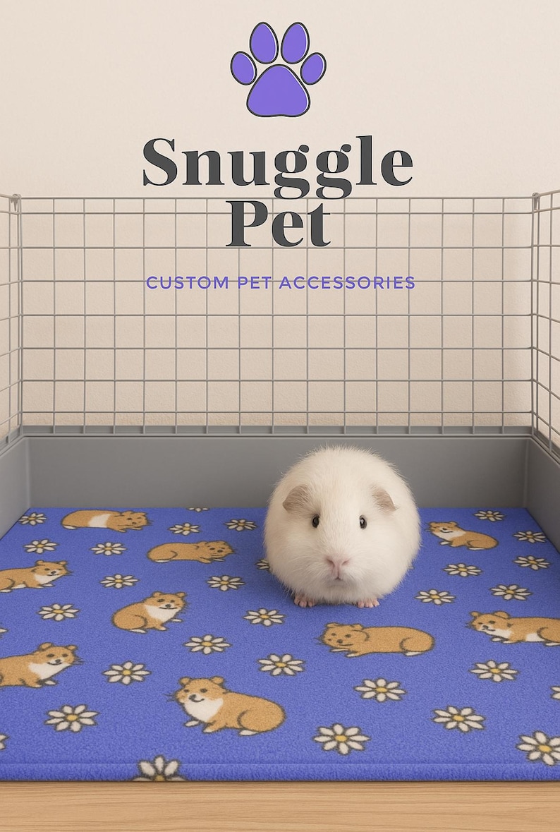May include: A white guinea pig sits on a blue fleece pet bed with a pattern of brown hamsters and white daisies. The bed is inside a wire cage. The text "Snuggle Pet CUSTOM-PET ACCESSORIES" is above the cage.