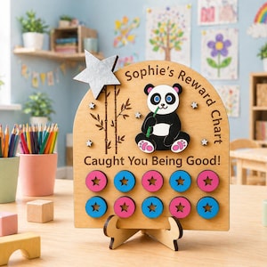 May include: A wooden reward chart featuring a panda illustration and the text "Sophie's Reward Chart Caught You Being Good!". The chart has pink and blue star-shaped tokens. A silver star and bamboo design are also featured.