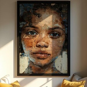 May include: A framed portrait of a person with brown skin and dark eyes. The artwork is displayed above a window seat with yellow pillows, a brown blanket, an open book, and a white mug. The room is lit by natural light.