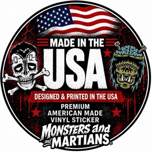 a sticker with a skull and crossbones design, along with an American flag and a monster or alien-like creature. The text on the sticker reads "MADE IN THE USA" and "DESIGNED & PRINTED IN THE USA", indicating that the sticker is made in the United States.