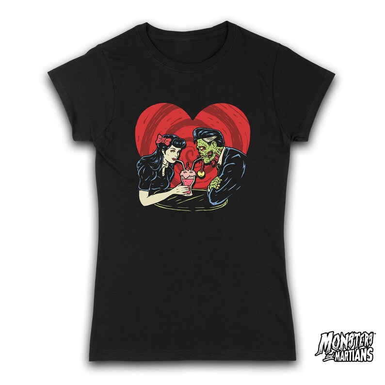 May include: Black t-shirt with a graphic of a zombie couple sharing a milkshake. The couple is surrounded by a red heart with a swirl pattern. The text "Monsters and Martians" is in the bottom right corner.