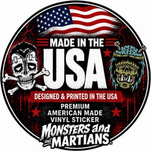 a sticker with a skull and crossbones design, along with an American flag and a monster or alien-like creature. The text on the sticker reads "MADE IN THE USA" and "DESIGNED & PRINTED IN THE USA", indicating that the sticker is made in the United States.