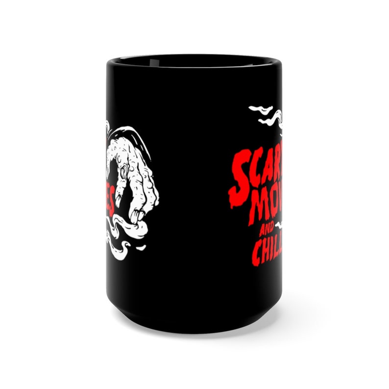 Peut inclure: Une tasse en c&eacute;ramique noire avec une illustration blanche d'une main sortant d'un nuage de fum&eacute;e. Le texte "Scary Movies and Chilling" est en lettres rouges.