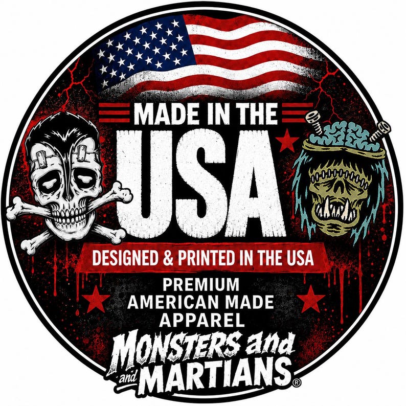 a circular logo with a skull and crossbones design, an American flag, and a monster or alien head. The text "MADE IN THE USA" is prominently displayed, along with the phrase "DESIGNED & PRINTED IN THE USA" and "PREMIUM AMERICAN MADE APPAREL" below. The phrase "MONSTERS and MARIANTS" is also included in the design.