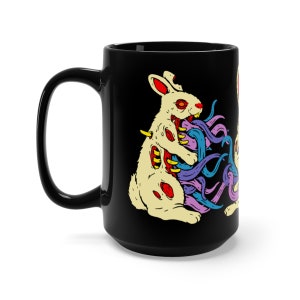 May include: Black ceramic coffee mug featuring a white rabbit biting another rabbit with colourful tentacles. The rabbit's insides are visible and the tentacles are purple, blue, and pink.