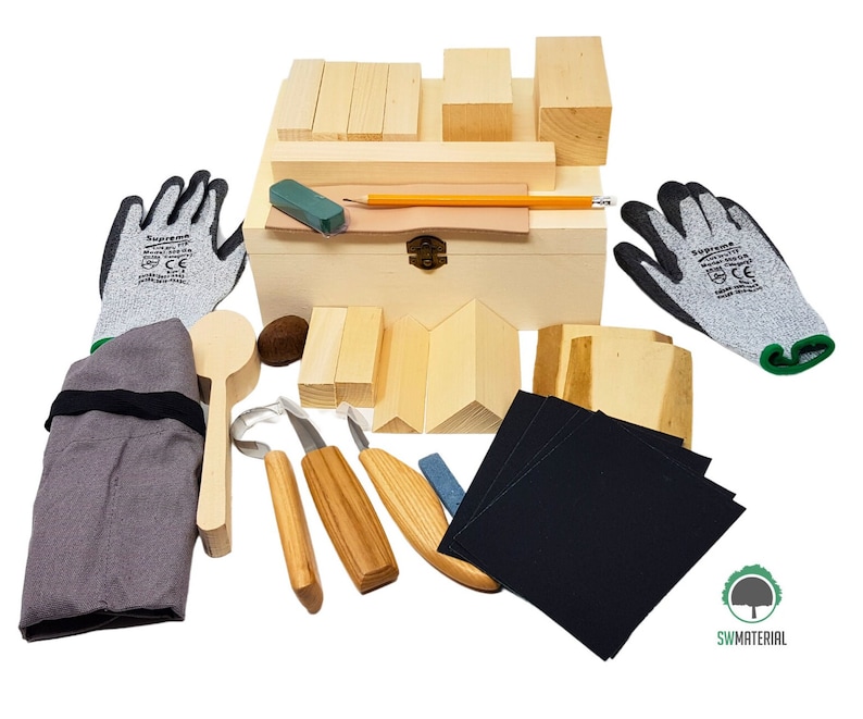May include: Wooden box filled with wood carving tools and supplies. The box contains a variety of wood carving tools, including knives, gouges, and a mallet. There are also several pieces of wood for carving, as well as sandpaper and a pencil. The box is made of wood and has a hinged lid. The box is labelled "SWMATERIAL".
