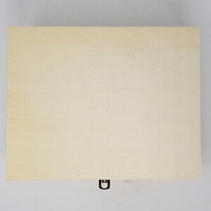 May include: A plain wooden box with a metal latch. The box is light brown and has a smooth surface.
