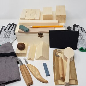 May include: Wooden spoon carving kit with tools, wood blanks, gloves, and a sharpening stone. The kit comes in a wooden box with a leather strap and a brass latch.