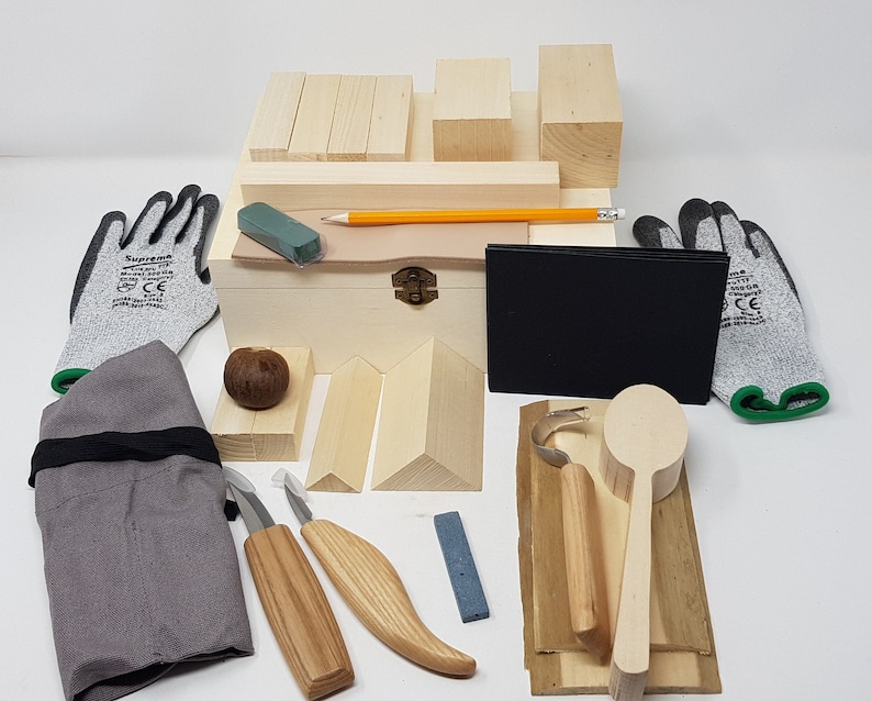 May include: Wooden spoon carving kit with tools, wood blanks, gloves, and a sharpening stone. The kit comes in a wooden box with a leather strap and a brass latch.