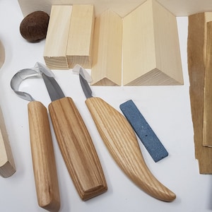 May include: A wood carving kit containing a wooden spoon, three carving tools, a sharpening stone, sanding paper, and wooden blocks for practice.