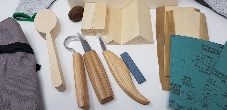 May include: A wood carving kit containing a wooden spoon, three carving tools, a sharpening stone, sanding paper, and wooden blocks for practice.