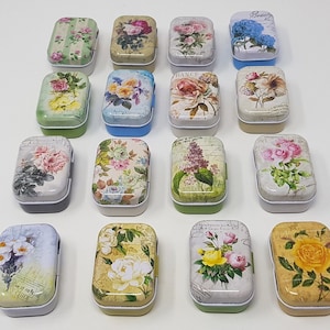 May include: Assortment of 14 small, rectangular metal tins with floral designs. The tins are in various colours, including white, blue, green, and pink. Each tin features a different floral pattern, including roses, lilies, and daisies.