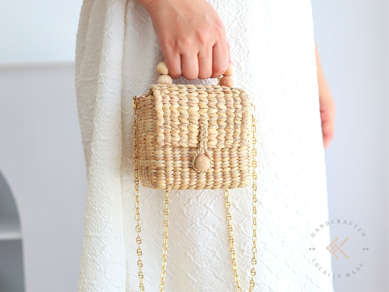 Girl in the white summer dress with small crossbody bag with gold chains strap
