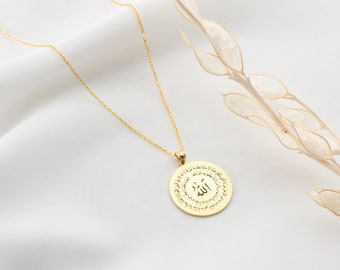 May include: A gold necklace with a round pendant featuring the Arabic word "Allah" surrounded by a circle of smaller Arabic script.