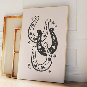 May include: A black and white illustration of three horseshoes with a star pattern. The horseshoes are overlapping and are surrounded by small stars.